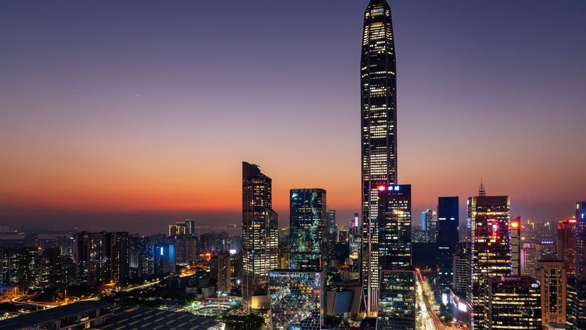 在橙紫渐变的天空下,一座充满活力的城市展现出无数灯火通明的摩天大楼和城市设施。